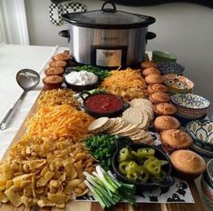 a table topped with lots of different types of food next to a crock pot