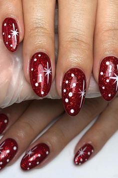 Sparkling with Holiday Magic! ✨❄️ Adorn your fingertips with these festive red almond gel nails, featuring a mesmerizing ruby-red holographic base sprinkled with delicate white dots. The ethereal snowfall details and starbursts will transport you to a winter wonderland, exuding the charm and enchantment of the holiday season. Get ready to shine bright and embrace the Christmas spirit! // Photo Credit: Instagram @gelsbykathicks Glitter Elegant Nails, Christmas Nails With Tree Design, Polka Dot Christmas Nails, Red With Glitter Nails, Sparkle Holiday Nails, Red Festive Nails, Baby Pink Christmas Nails, Red And Silver Christmas Nails, Christmas Sparkle Nails