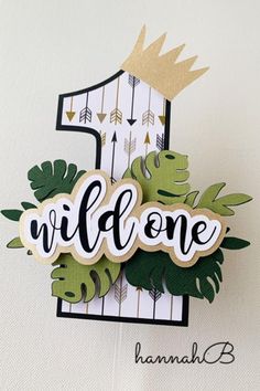 a handmade card with the word wild one on it, surrounded by leaves and arrows