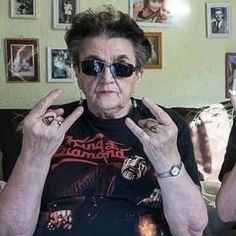 an older woman sitting on a couch with her hands in the air and wearing sunglasses