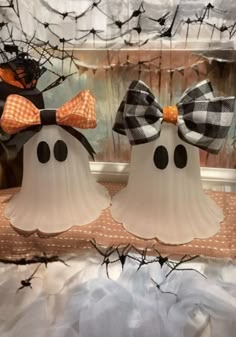 two white pumpkins decorated with black and orange bows