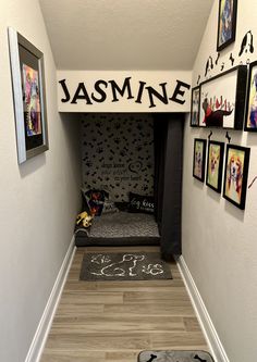 a hallway with pictures on the wall and a dog bed in the corner that says'jasmine '