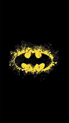 the batman symbol painted in yellow and black with paint splattered on it's face