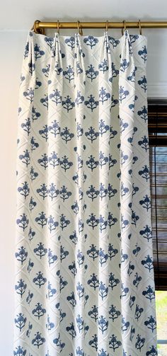 a curtain with blue and white designs hanging from it's valance in front of a window