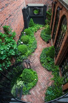 an aerial view of a small courtyard with brick walls and green plants on the ground