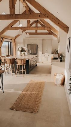 an open floor plan with white walls and wood beams