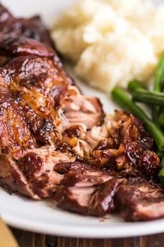 a plate with meat, green beans and mashed potatoes