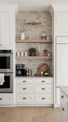 a kitchen with white cabinets and open shelving