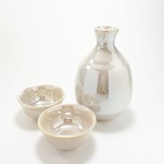 two bowls and a vase sitting next to each other