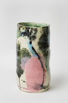 a ceramic vase with an abstract design on the outside and pink, blue, green, black and white paint