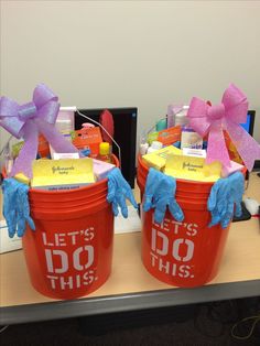 two red buckets with blue gloves and pink bows on them that say let's do this