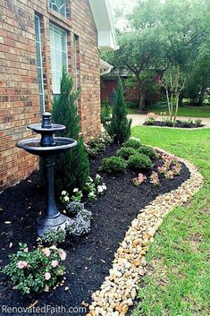 a bird bath in front of a brick house