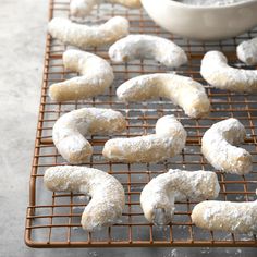 powdered sugar coated doughnuts on a cooling rack