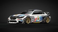 the bmw race car is painted with colorful paint and gold rims on it's body