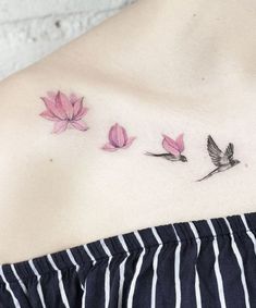 a woman's chest with pink flowers and leaves on her left side ribcage