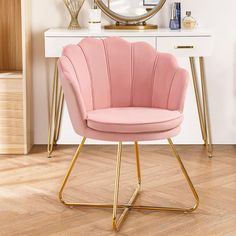 a pink chair sitting in front of a white desk with a mirror on top of it