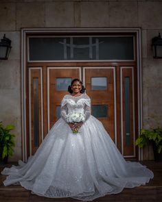 a woman standing in front of a door wearing a wedding dress