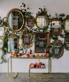 a table with flowers, candles and menus on it in front of a wall