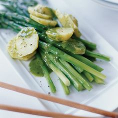 asparagus and potatoes on a white plate with chopsticks