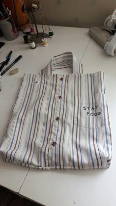 a bag sitting on top of a white table next to scissors and other craft supplies