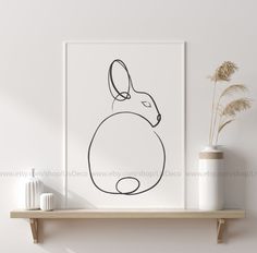 a black and white line drawing of a rabbit on a shelf next to a vase