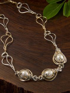 "I designed flowing swirls of silver and gold with a handmade chain reminiscent of waves to compliment the freshwater pearls. The soft luster of the pearls and the combination of silver and gold create distinctive, timeless jewelry pieces. " - Laura Glen More Information Necklace Sterling Silver and Gold Filled Freshwater pearls Sterling Silver lobster claw clasp 20" long- adjustable If you need a different length, please contact me Earrings shown with the set are freshwater pearls set with ster Elegant Silver Spiral Jewelry, Elegant Spiral Necklaces For Jewelry Making, Elegant Silver Spiral Necklace, Elegant Spiral Wire Wrapped Jewelry, Elegant White Gold Wavy Jewelry, Elegant Wavy White Gold Jewelry, Elegant Wavy Silver Jewelry, Elegant Silver Wire-wrapped Pearl Necklace, Elegant Silver Wire Wrapped Pearl Necklace