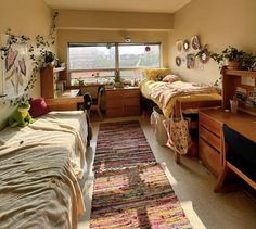 a bedroom with two twin beds and a rug on the floor in front of it