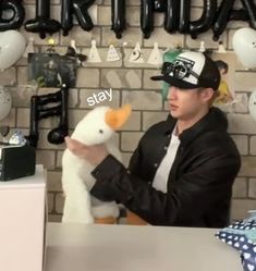 a man sitting at a table with a stuffed animal in front of him that says stay