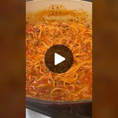 a pot filled with spaghetti and sauce on top of a stove