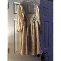 a dress hanging on a door hanger in front of a white door with a blue door