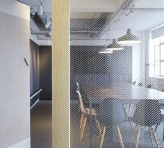 an empty conference room with chairs and a table in front of a wall that has mesh coverings on it