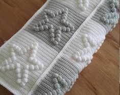 two crocheted dishcloths sitting on top of a wooden table