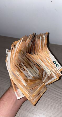 a person holding up several stacks of money