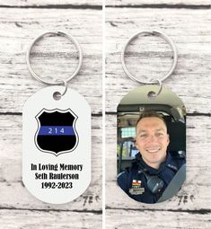 two key chains with the words in loving memory and an image of a police officer