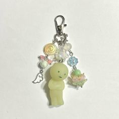 a keychain with a small plastic toy on it's side and various charms attached to it