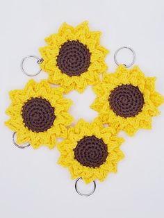 four crocheted sunflowers sitting on top of each other in the shape of a keychain