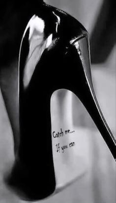 a black high heeled shoe with the words catch me if you can written on it