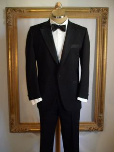 This is a super tuxedo with tone on tone design on the lapels. pockets, buttons, side stripe of trousers and on the attached cumberbund. Jacket is fully lined and trousers are partially lined. Maker: Lebaron California Clothes for Dorman Winthrop Fabric content: Not listed Care: Dry clean Condition: Great, overall, but there are two tiny moth bites (?) about 5 1/2 inches under the left pocket (laying flat).  Size: 44 Short (as labeled but please refer to measurements) Measurements: (Laying on a flat surface, double where necessary) Jacket: Shoulder to shoulder: 18 inches Underarm to underarm: 23 inches Waist: 23 inches Hips: 24 inches Sleeve length: 24 inches Length: 32 inches Trousers: Waist: 20 inches Inseam: 27 1/2 inches with a 2 1/2 inch hem Length: 38 1/4 inches Evening Tailored Double Breasted Suit With Pressed Crease, Black Tuxedo With Pressed Crease For Evening, Formal Tuxedo Suit With Hidden Button Closure, Classic Single Button Evening Tuxedo, Black Evening Tuxedo With Pressed Crease, Tailored Three-piece Suit With Pressed Crease For Evening, Tailored Three-piece Evening Suit With Pressed Crease, Evening Tailored Three-piece Suit With Pressed Crease, Evening Three-piece Tailored Suit With Pressed Crease