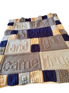 a crocheted blanket with blue and beige squares