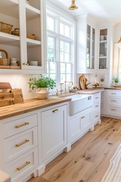 a kitchen with white cabinets and wooden counter tops