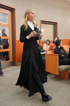 a woman standing in front of a room holding a microphone