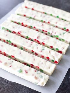 white chocolate covered with candy canes on top of a piece of parchmented paper