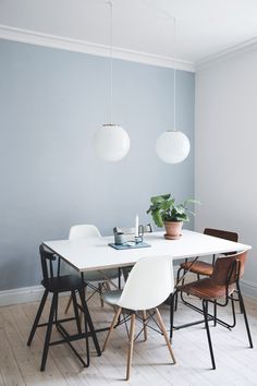 a dining room table with chairs and a potted plant on top of the table