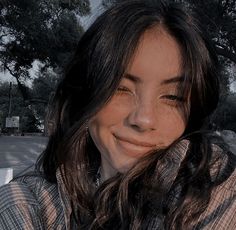 a woman with her eyes closed sitting on a bench