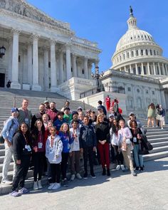 a group of people standing in front of the capital building