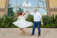 a man and woman dancing in front of a building