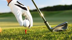 a golf player is about to put his ball into the hole on the green grass