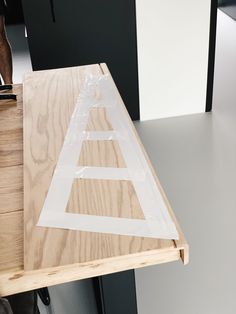 a piece of plywood is taped to the side of a table with tape on it