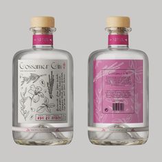 two bottles with labels on them sitting next to each other in front of a gray background