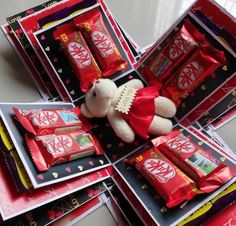 a teddy bear sitting on top of a pile of assorted candy bars and candies